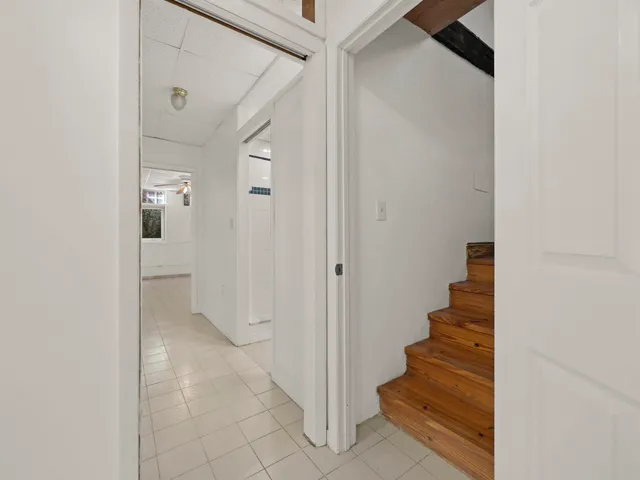 a view of a hallway with staircase and white walls