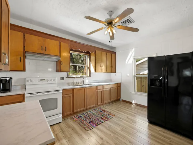 a kitchen with a refrigerator cabinets and wooden floor