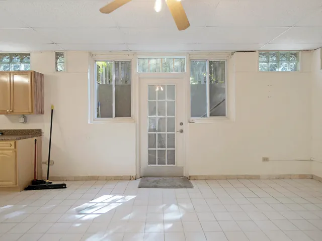 a view of an empty room with window and bathroom