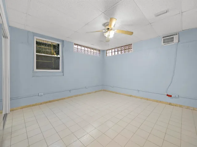 an empty room with windows and fan