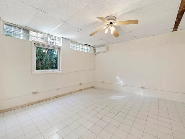 an empty room with windows and fan