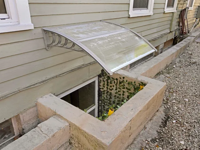 a view of staircase with lots of frames on wall and a potted plant