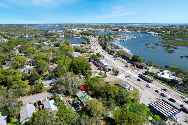 an aerial view of a city with lots of residential buildings ocean and mountain view in back