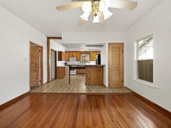 a view of a room with wooden floor and a kitchen space