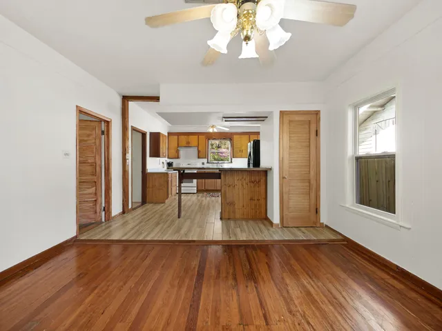 a view of a room with wooden floor and a kitchen space