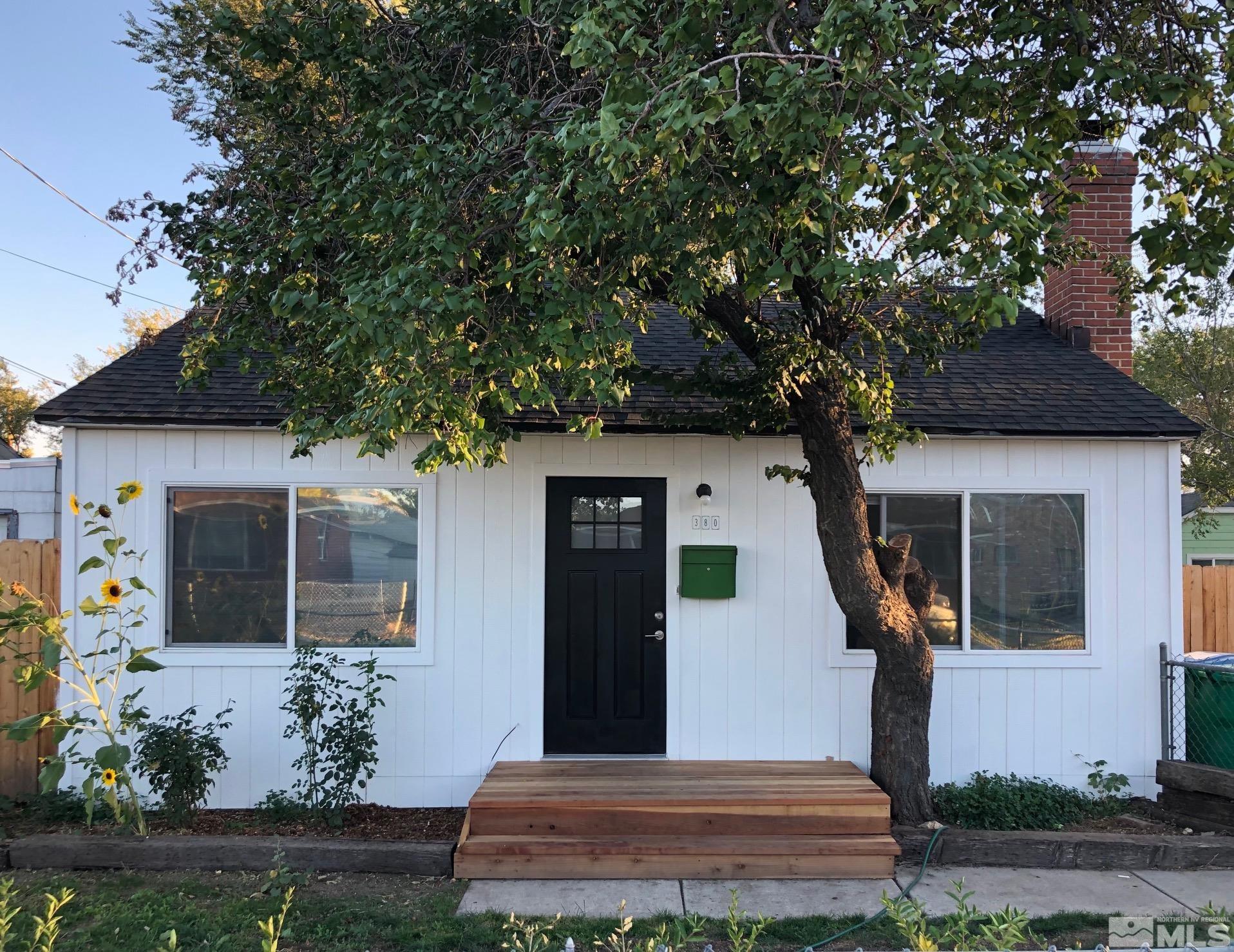 a front view of a house with potted plants