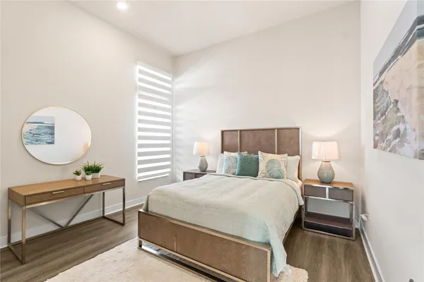 a bedroom with a bed a mirror and a window