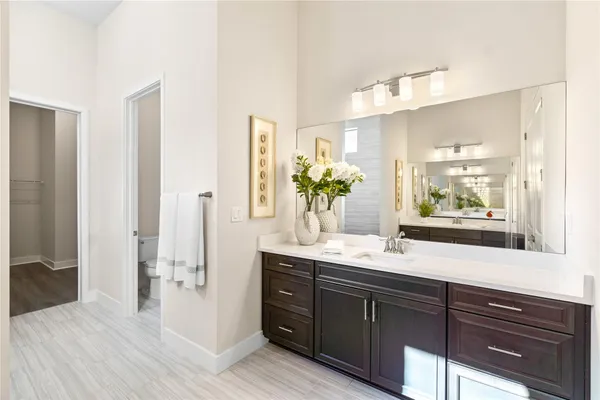 a bathroom with a double vanity sink and mirror with shower