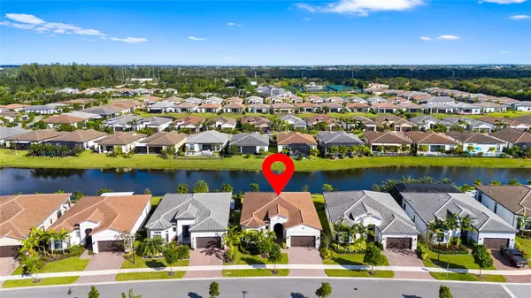 an aerial view of residential houses with outdoor space and lake view