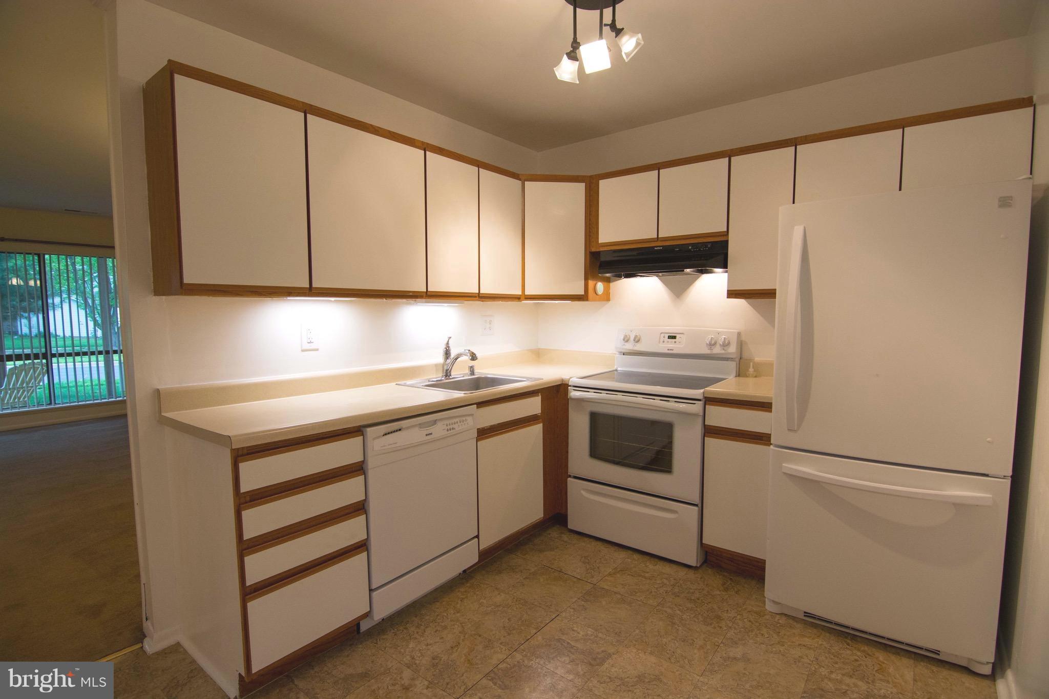 2221 Notely Lane Crofton, MD 21114 - Photo 6 of 26 a kitchen with a white cabinets and white appliances