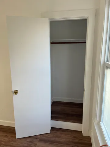 a view of walk in closet with wooden floor