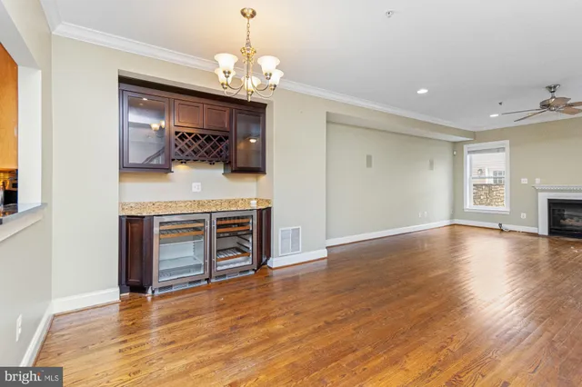 a view of a livingroom with a fireplace a chandelier and wooden floor