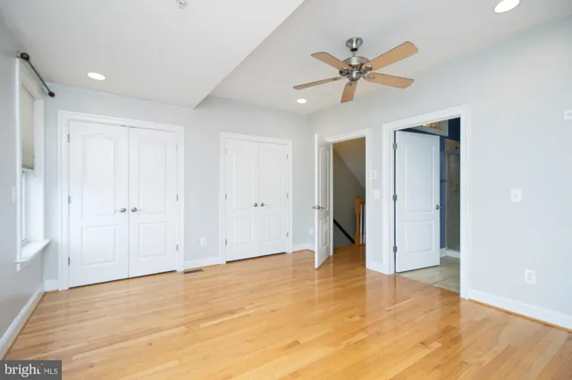 a view of a livingroom with a ceiling fan and wooden floor
