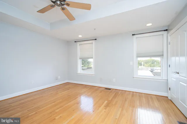 an empty room with a window and a ceiling fan