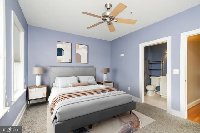 a view of a livingroom with a chandelier fan and windows