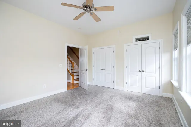 an empty room with a window and a fan