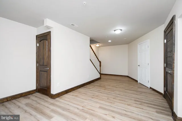 an empty room with wooden floor and closet