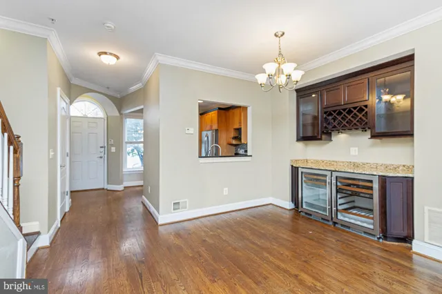 a view of a livingroom with a chandelier fan and wooden floor