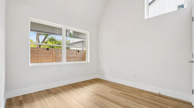 an empty room with wooden floor and a window