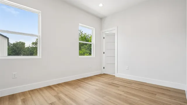 an empty room with wooden floor and window