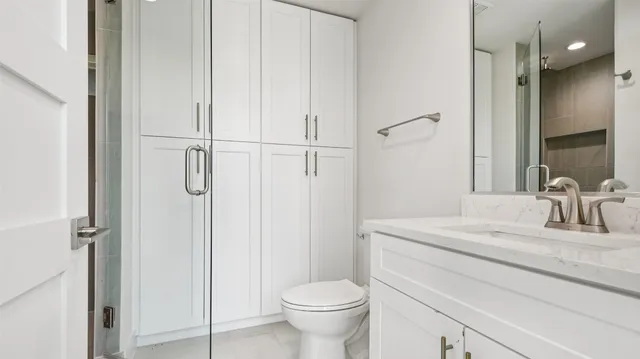 a bathroom with a granite countertop sink toilet and shower