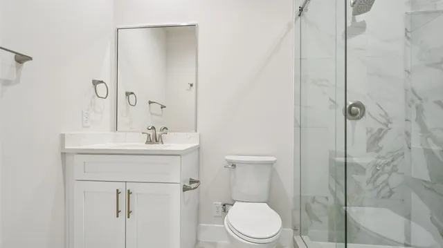 a bathroom with a sink a toilet and shower