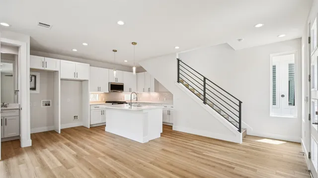 a kitchen with white cabinets and stainless steel appliances