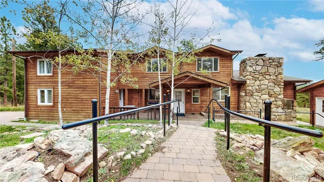 a front view of a house with a yard and potted plants