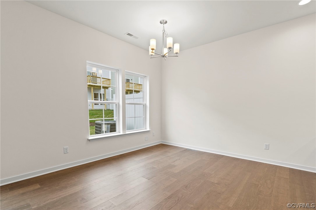 11252 Benton Pointe Way Chester, VA 23831 - Photo 9 of 26 an empty room with chandelier and windows