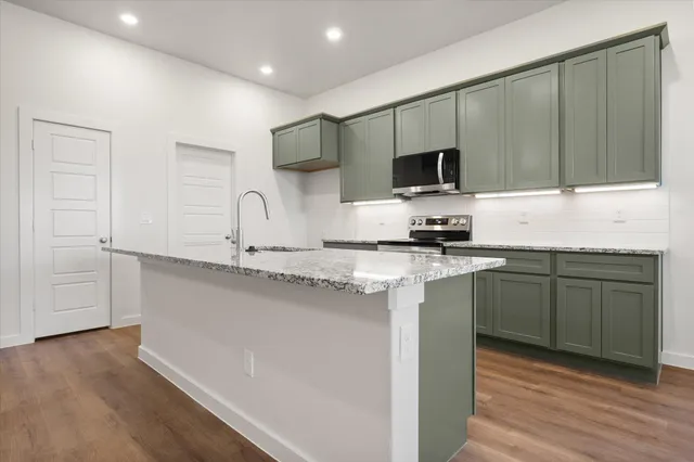 a kitchen with granite countertop a sink and cabinets