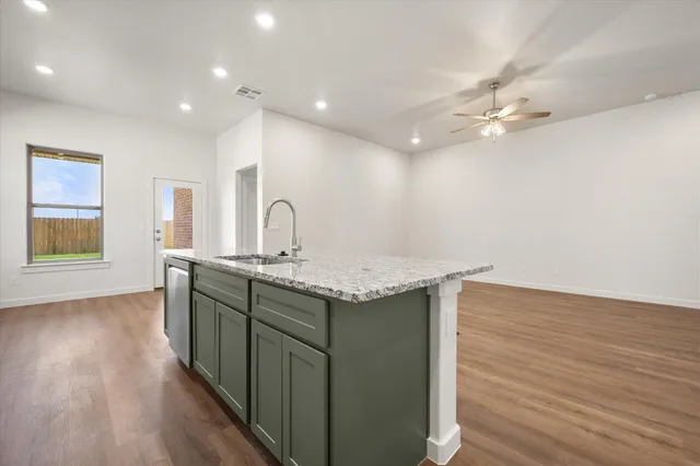 a kitchen with kitchen island a sink and wooden floor