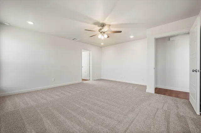 wooden floor in an empty room with a ceiling fan