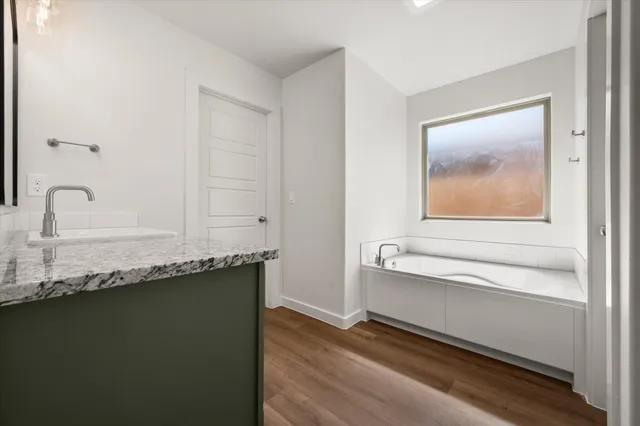 a bathroom with a granite countertop sink and a mirror