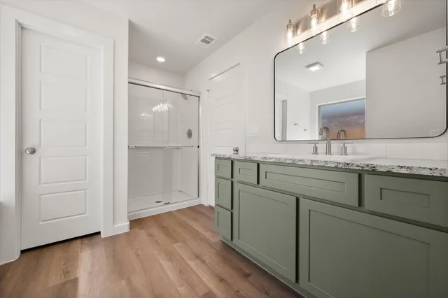 a bathroom with a granite countertop sink mirror and shower