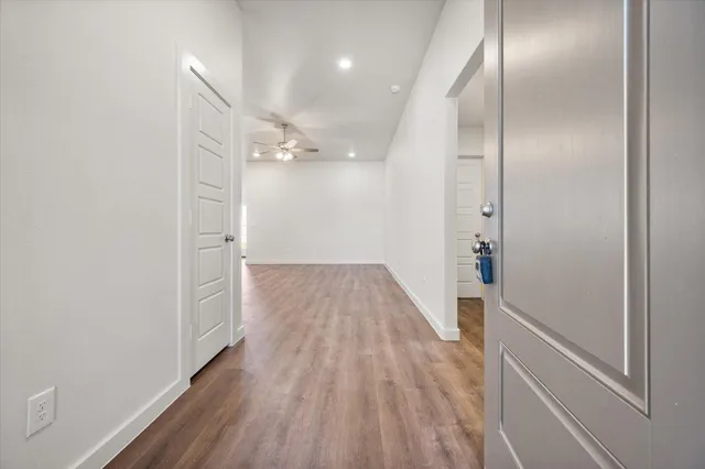 a view of a hallway with wooden floor