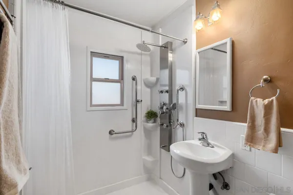 a bathroom with a sink a toilet and shower