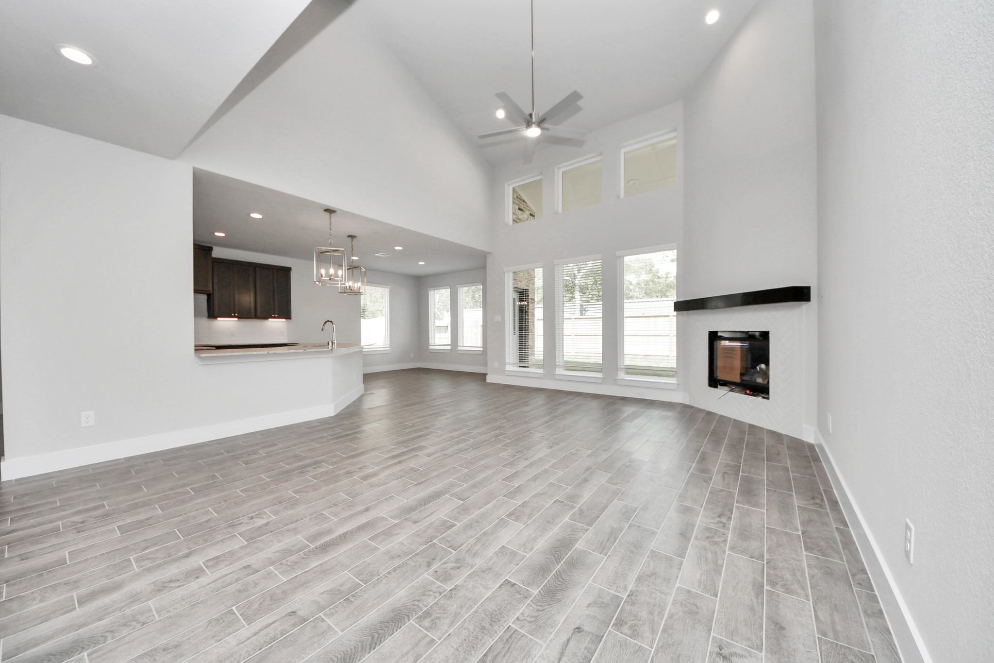 3110 Native Spg Drive Spring, TX 77373 - Photo 15 of 34 Family room flooded with natural light through the expansive windows. The premium tile flooring adds a touch of luxury to the space, creating the perfect setting for relaxing moments and cherished gatherings with loved ones. Sample photo of completed home with similar floor plan. Actual colors and selections may vary.