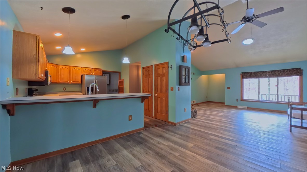 48276 Dyke Road Negley, OH 44441 - Photo 6 of 30 Kitchen featuring a breakfast bar area, light countertops, hanging light fixtures, dark wood-style floors, and a ceiling fan