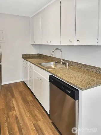 a kitchen with granite countertop white cabinets and sink
