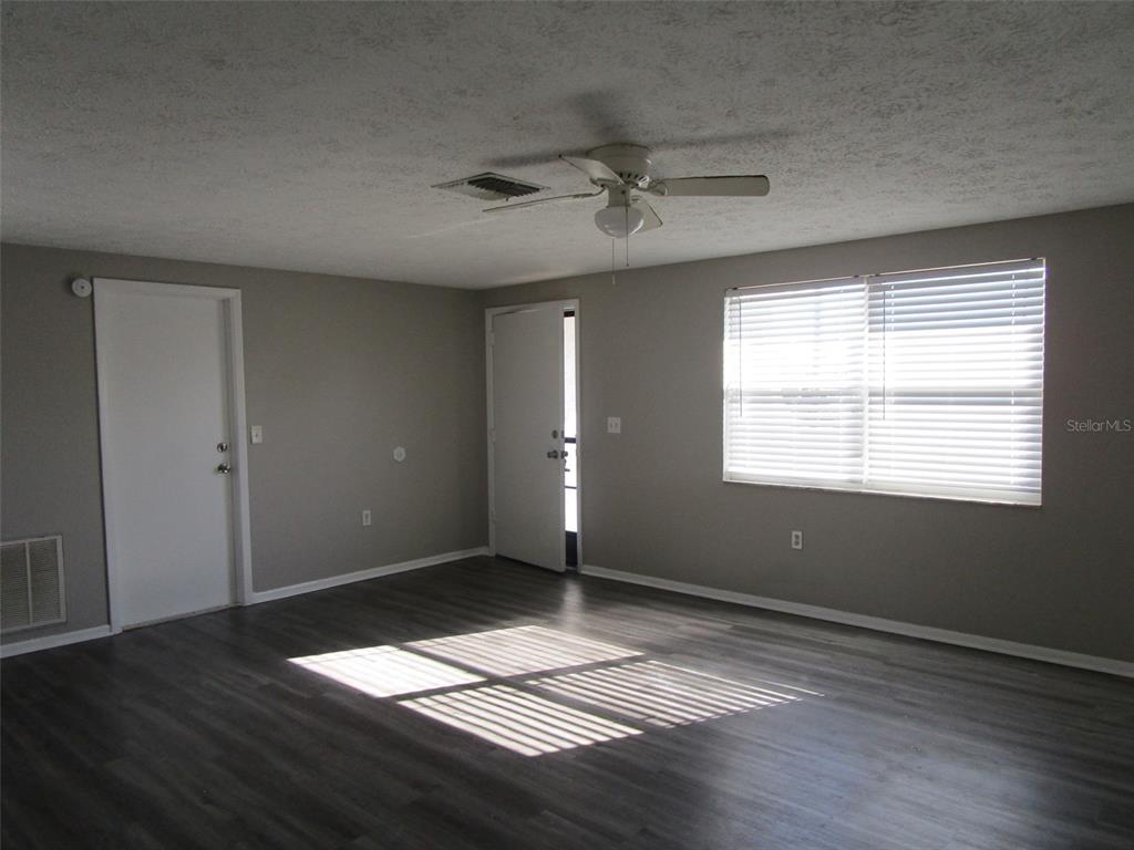 8947 Cairo Lane Port Richey, FL 34668 - Photo 11 of 17 a view of an empty room with wooden floor and a window