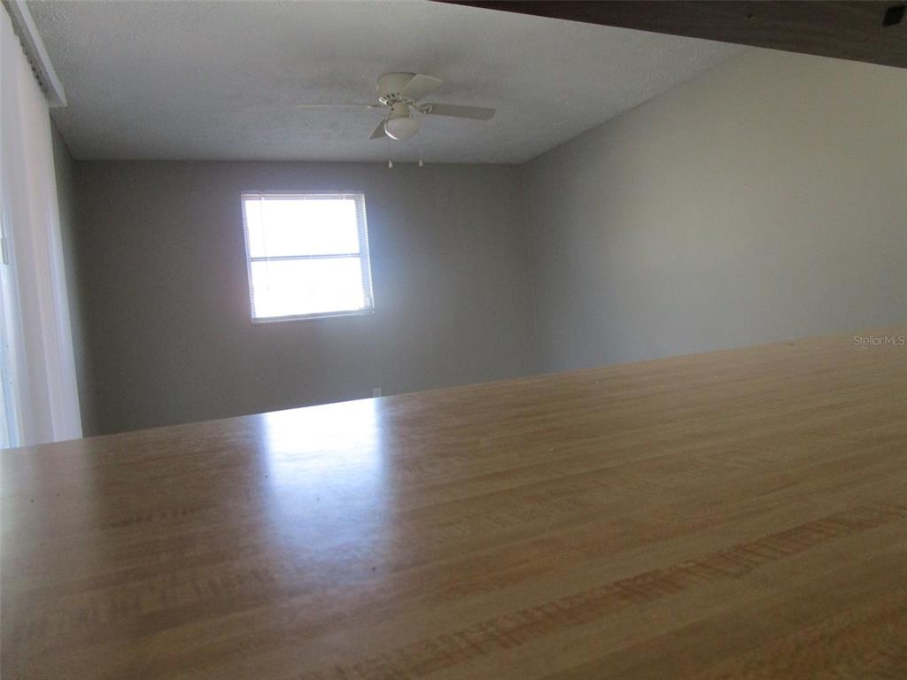 8947 Cairo Lane Port Richey, FL 34668 - Photo 15 of 17 a view of an empty room with wooden floor and a window