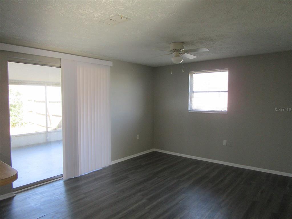 8947 Cairo Lane Port Richey, FL 34668 - Photo 16 of 17 an empty room with wooden floor and windows