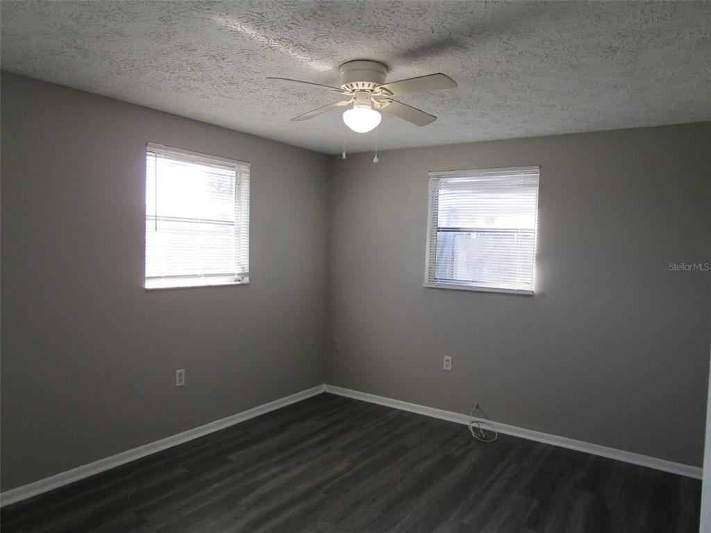 8947 Cairo Lane Port Richey, FL 34668 - Photo 4 of 17 an empty room with wooden floor and windows