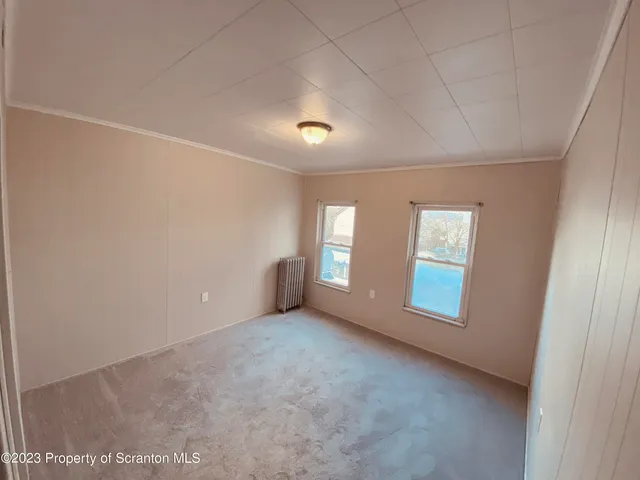 an empty room with an entryway and fan