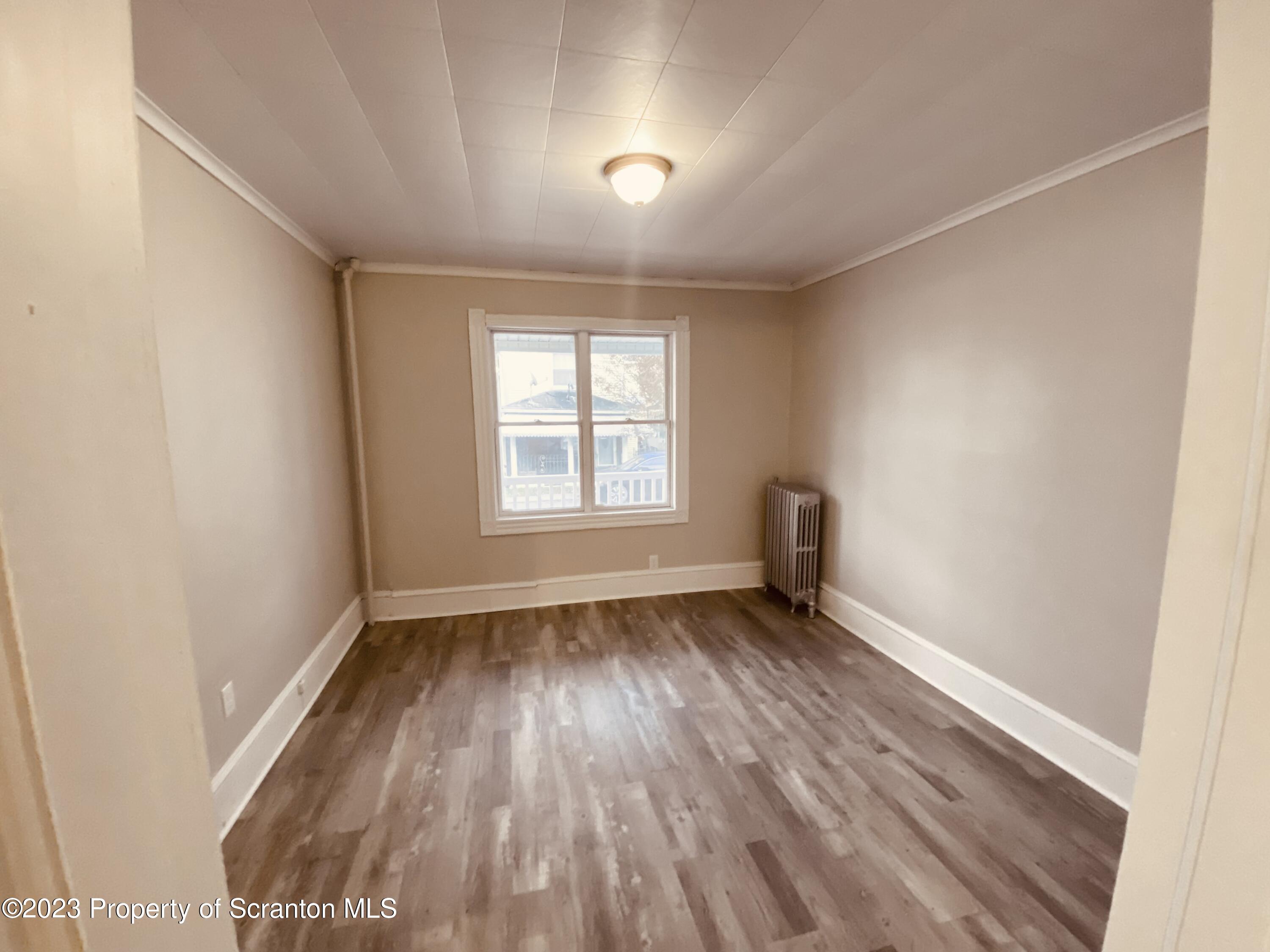 916 South 9th Avenue Scranton, PA 18504 - Photo 5 of 18 an empty room with wooden floor and windows