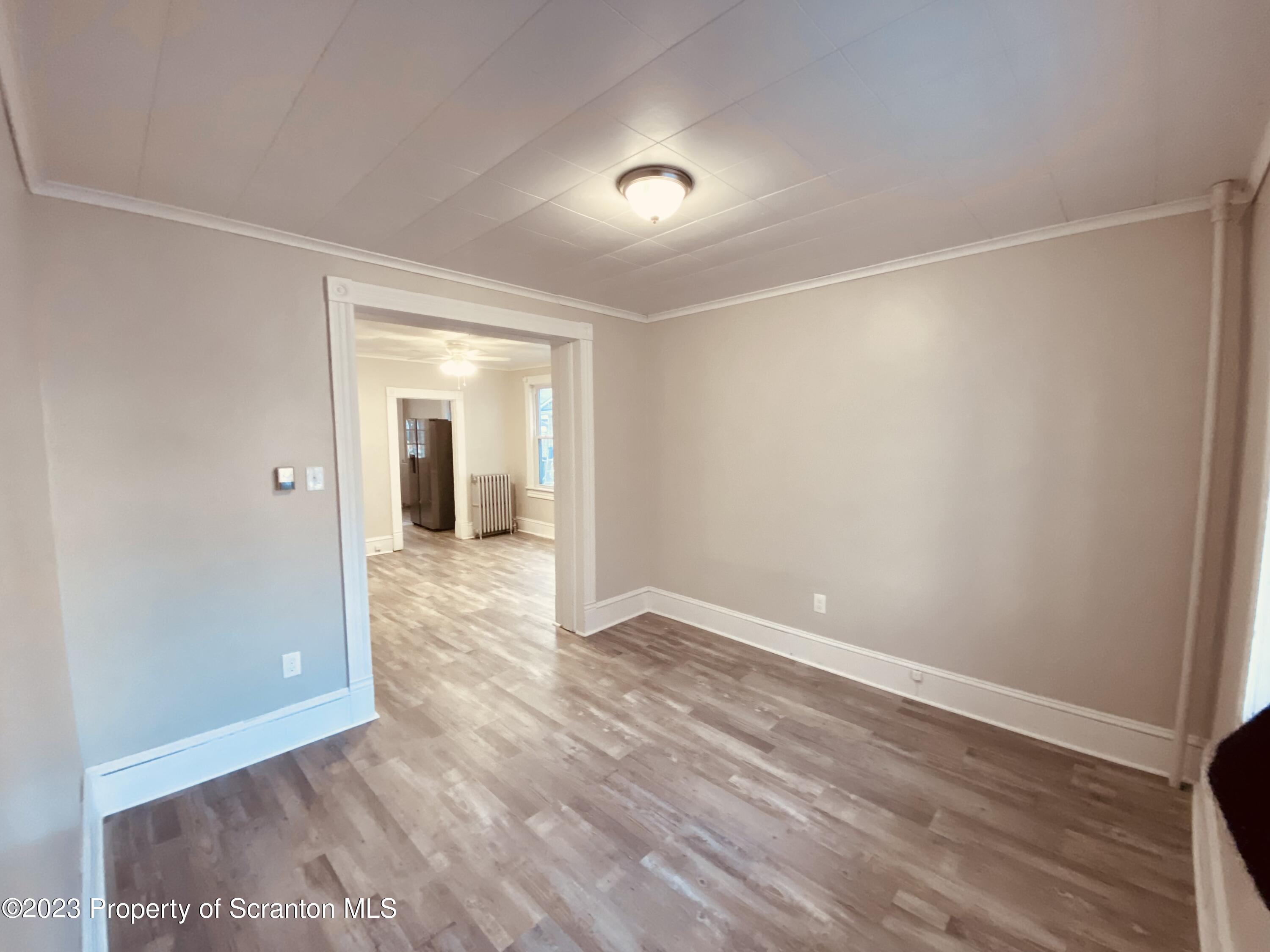 916 South 9th Avenue Scranton, PA 18504 - Photo 6 of 18 a view of an empty room with wooden floor and a window
