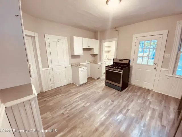 a kitchen with a refrigerator stove and white cabinets