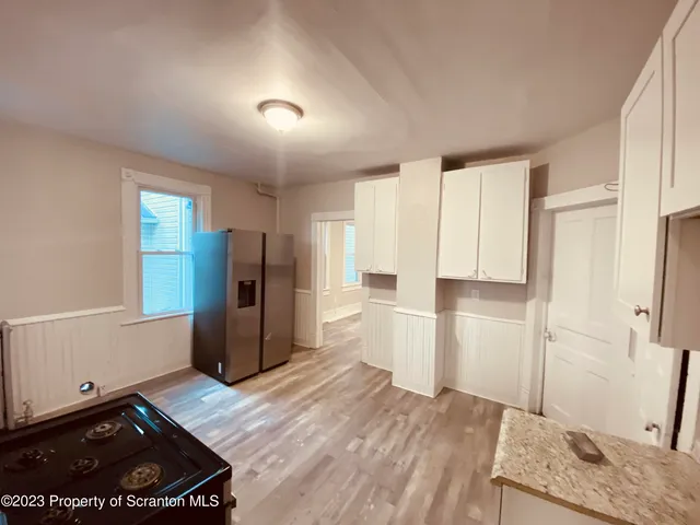 a kitchen with a refrigerator and a stove top oven