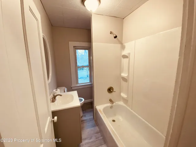 a bathroom with a tub sink and mirror