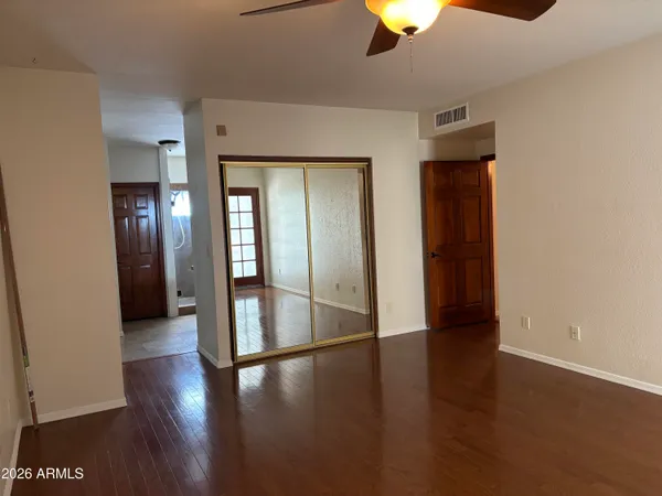 an empty room with wooden floor and windows